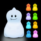 White ghost-shaped night light with colorful ghost figures on a black background