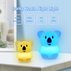 Two koala night lights, one yellow and one blue, on a surface with a blurred background.